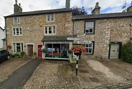 Quaint stone buildings with a small shop and cobbled street in a picturesque British village setting