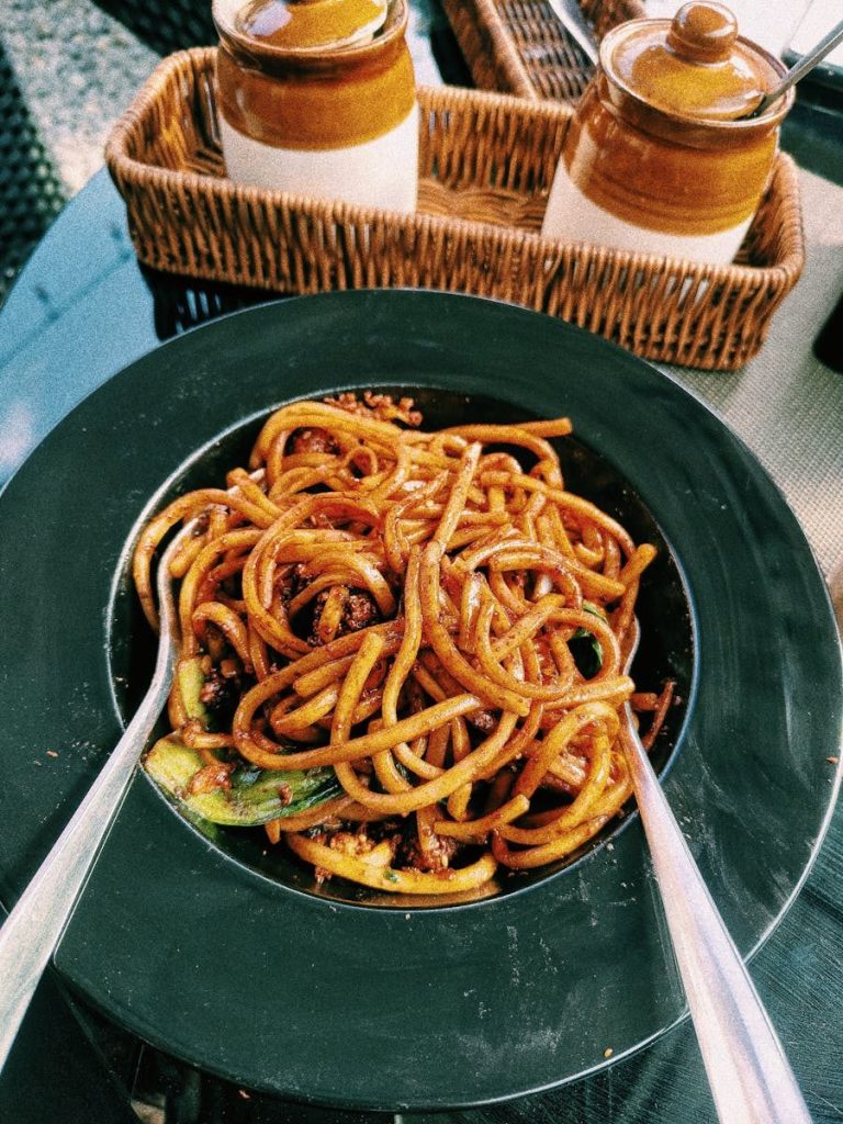 Mouthwatering spicy noodles served al fresco with condiments nearby