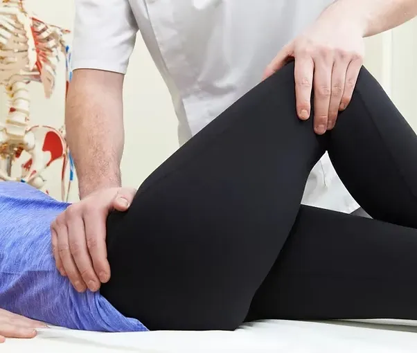 Physiotherapist performing leg therapy on patient in clinic setting