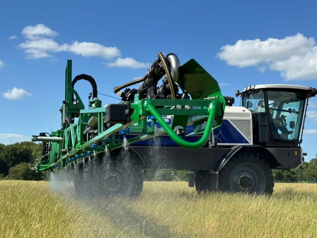 Modern agricultural sprayer in operation on a sunny field, highlighting advanced farming techniques and machinery