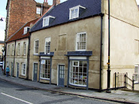 Historic terraced buildings with traditional shopfronts and sash windows on a quiet street in a quaint British town