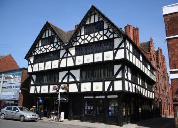 Tudor-style black and white building on a sunny street, showcasing traditional British architecture and design