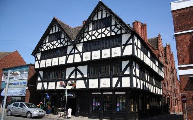Tudor-style black and white building on a sunny street, showcasing traditional British architecture and design