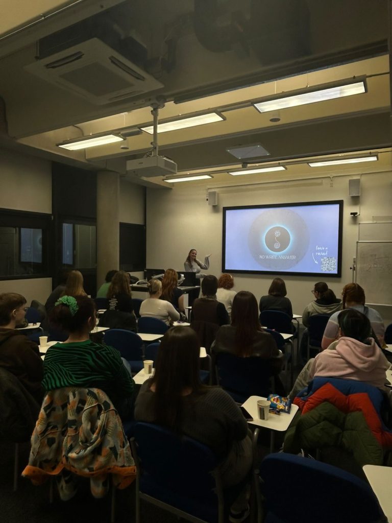 Students attentively listen to a presentation in a university classroom setting