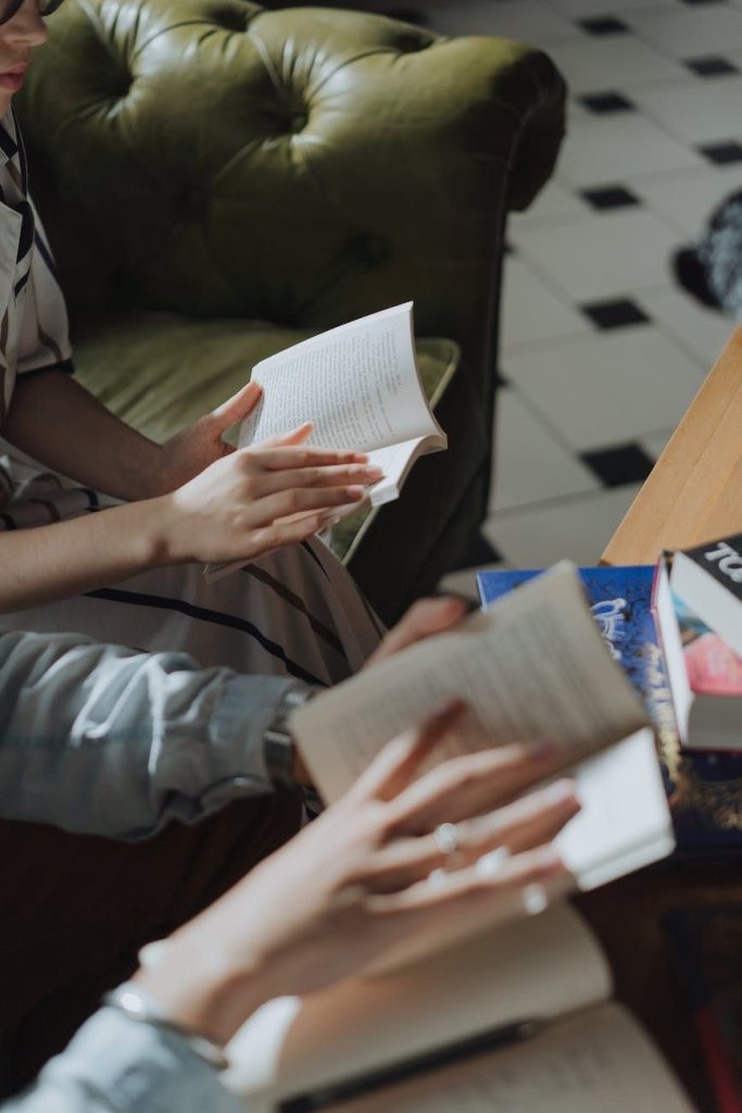 People reading books on a cosy green sofa in a stylish living room, promoting relaxation and learning