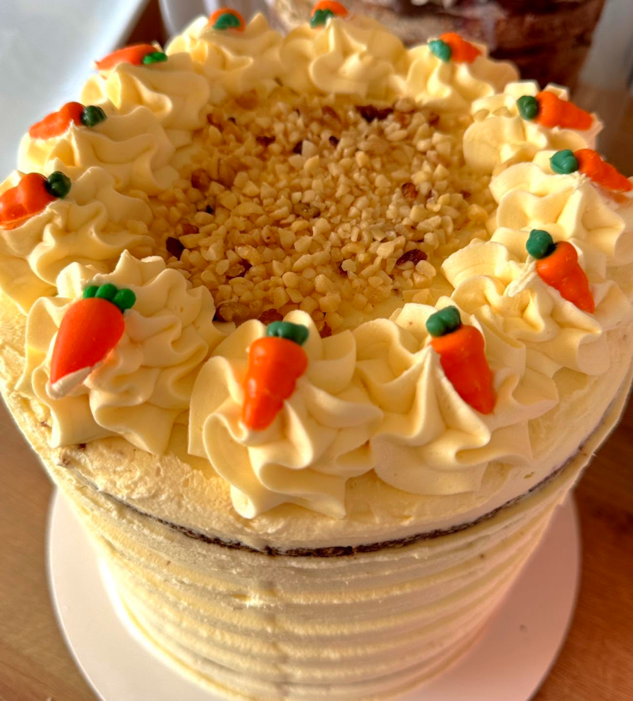 Delicious homemade carrot cake with cream cheese frosting and decorative carrot toppers