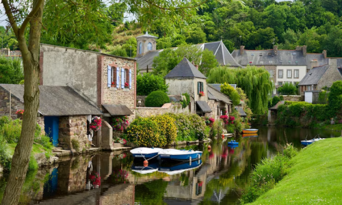 Charming village scene in France with stone houses, vibrant flowers, and calm river, perfect for a serene getaway